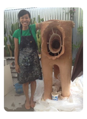 Artist Ako Castuera stands next to their sculpture titled The Portal